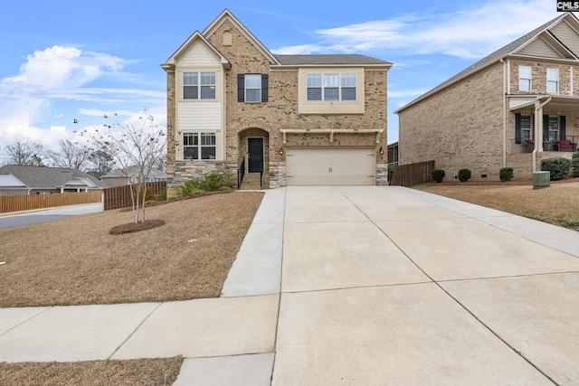 traditional home featuring fence, brick siding, driveway, and a garage