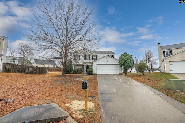 traditional-style house featuring fence, a residential view, driveway, and an attached garage