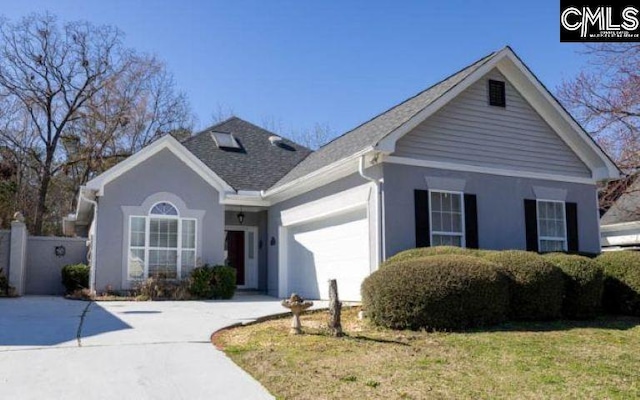 ranch-style home featuring a front yard, concrete driveway, and an attached garage