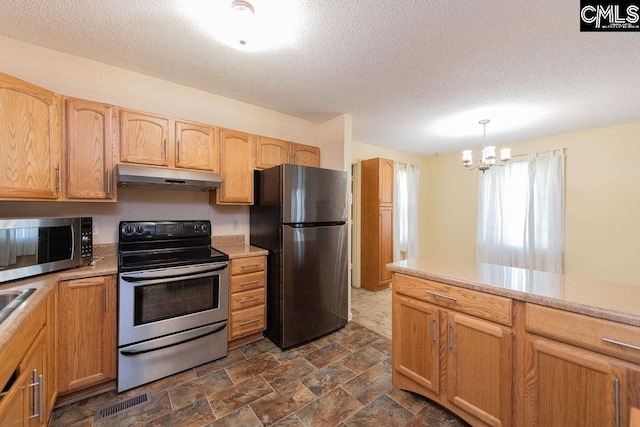 kitchen featuring pendant lighting, stainless steel appliances, light countertops, and under cabinet range hood