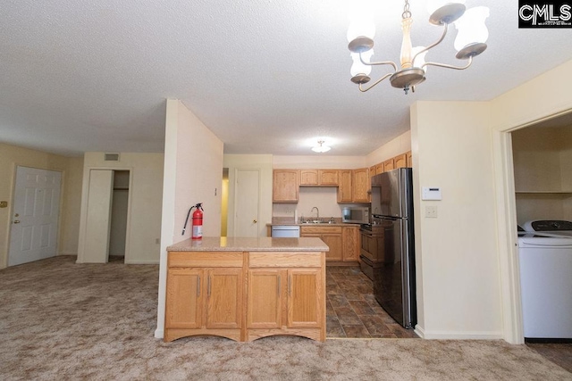 kitchen featuring a peninsula, stainless steel appliances, light countertops, washer / clothes dryer, and dark carpet