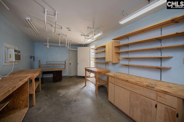 basement with a workshop area and a wall unit AC