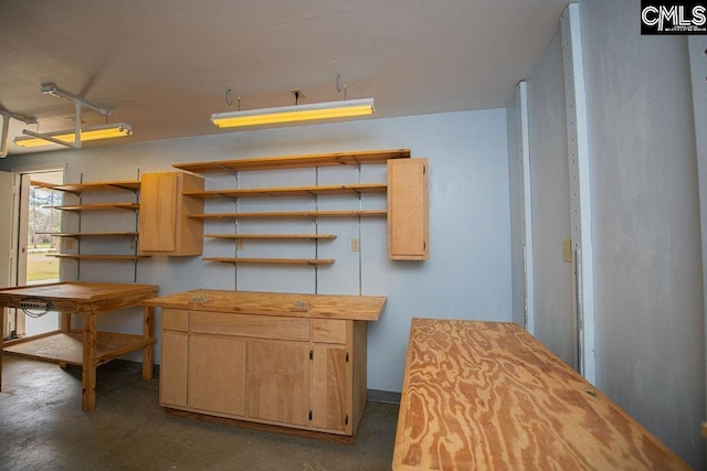 kitchen with concrete flooring, open shelves, light brown cabinetry, and wooden counters