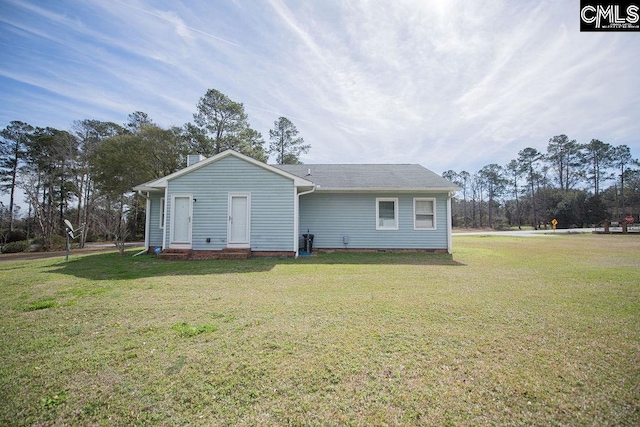 rear view of house featuring a yard and crawl space