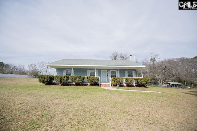 view of front of house featuring covered porch, a chimney, and a front lawn