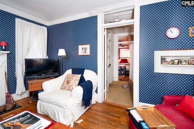 living area with a textured ceiling, wood finished floors, and wallpapered walls