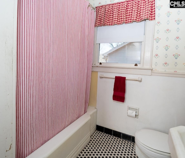 bathroom featuring shower / tub combo, baseboards, toilet, and wallpapered walls