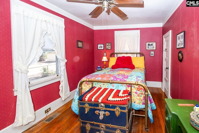 bedroom featuring ornamental molding, multiple windows, dark wood finished floors, and visible vents