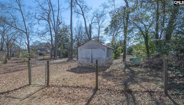 view of yard with a shed, fence, and an outbuilding