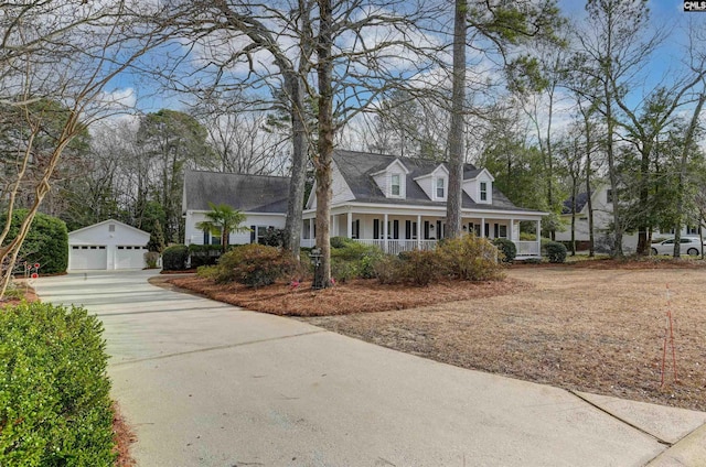 cape cod home with covered porch, a detached garage, and an outdoor structure