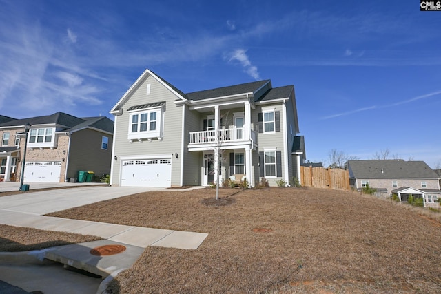 view of front of home with driveway, an attached garage, fence, and a balcony