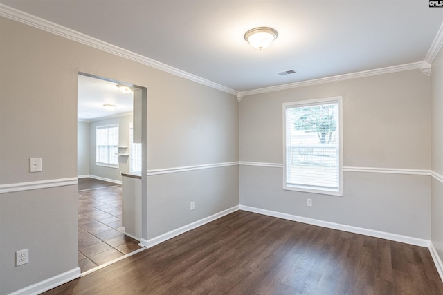 spare room featuring ornamental molding, dark wood finished floors, visible vents, and baseboards