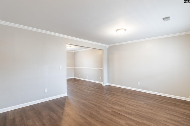 unfurnished room featuring baseboards, visible vents, dark wood-style flooring, and ornamental molding