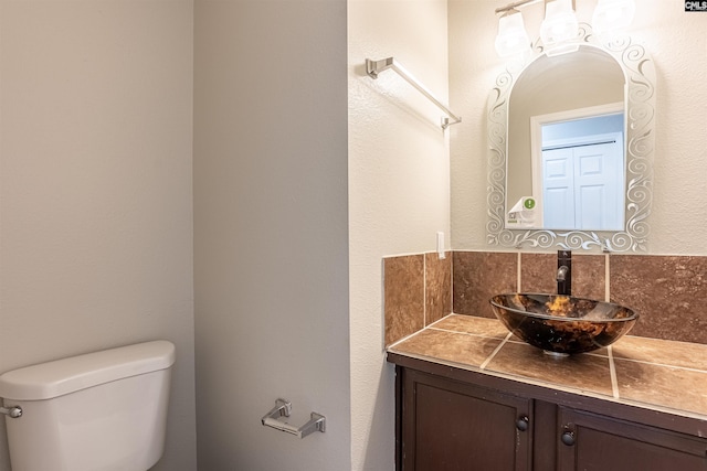 half bathroom featuring vanity and toilet