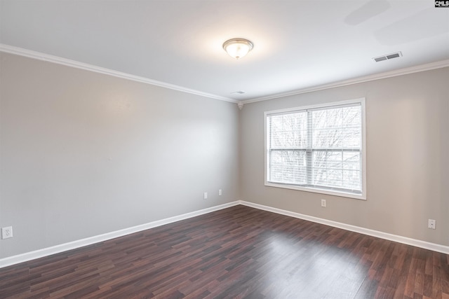 spare room with ornamental molding, visible vents, dark wood finished floors, and baseboards