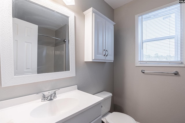 full bath featuring toilet, a textured wall, a shower, and vanity