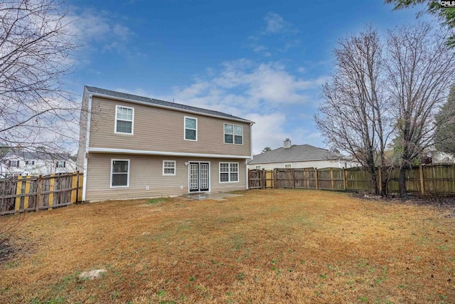 rear view of house featuring a fenced backyard and a yard