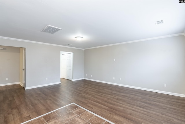 unfurnished room featuring baseboards, dark wood-style flooring, visible vents, and crown molding