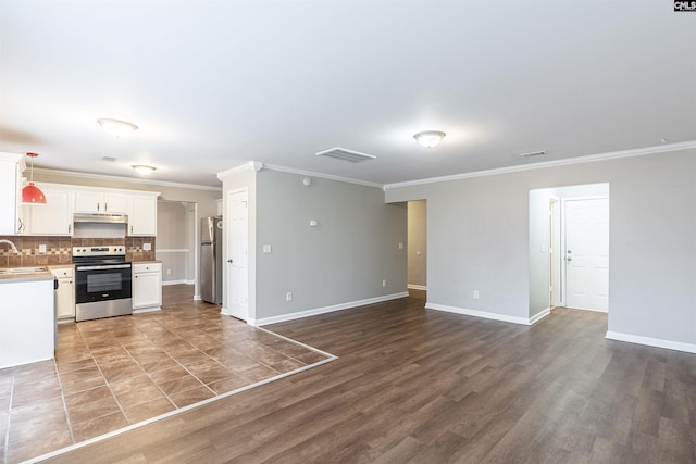 kitchen with stainless steel appliances, white cabinetry, open floor plan, light countertops, and backsplash