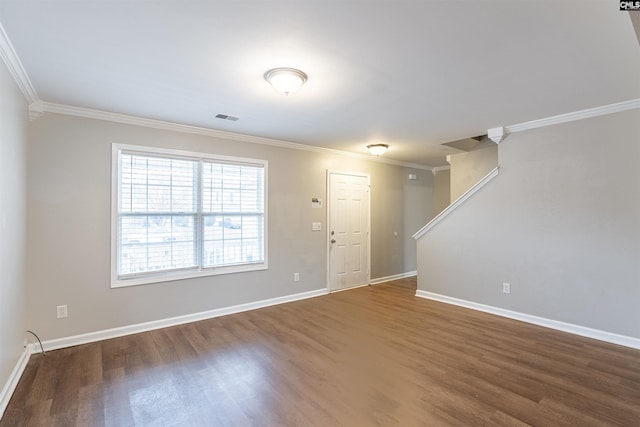 unfurnished room featuring ornamental molding, dark wood finished floors, visible vents, and baseboards