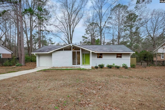 view of front of property with concrete driveway, brick siding, an attached garage, and fence