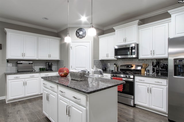 kitchen featuring pendant lighting, dark wood-style flooring, appliances with stainless steel finishes, white cabinetry, and a kitchen island