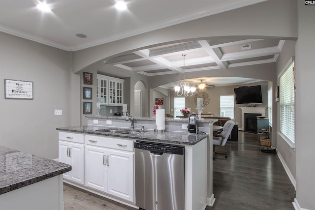 kitchen with pendant lighting, white cabinets, a sink, dark stone countertops, and dishwasher