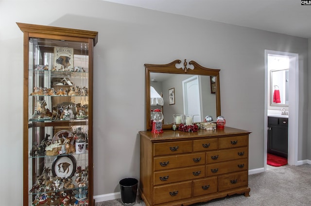 interior space featuring carpet, baseboards, and a sink