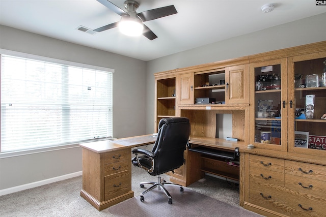 home office featuring a wealth of natural light, visible vents, dark carpet, and baseboards