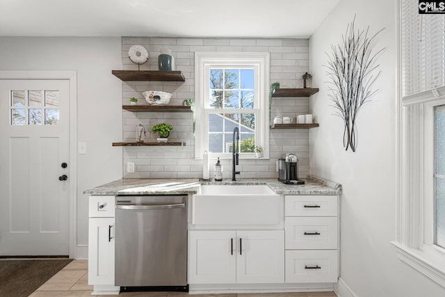 bar with a sink, baseboards, decorative backsplash, and dishwasher