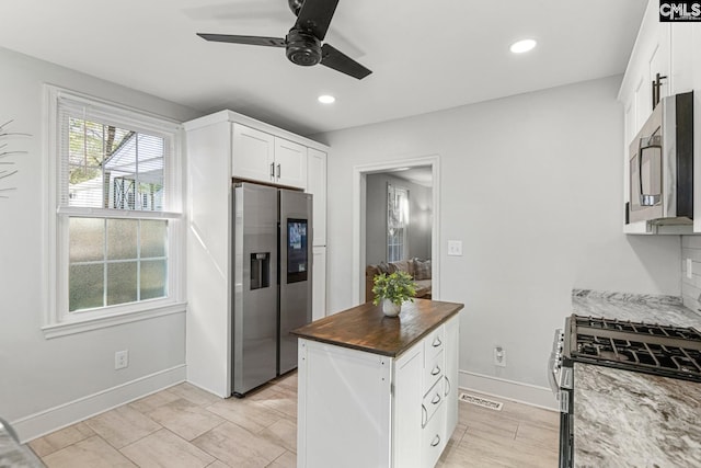 kitchen featuring stainless steel appliances, recessed lighting, visible vents, white cabinetry, and dark stone countertops