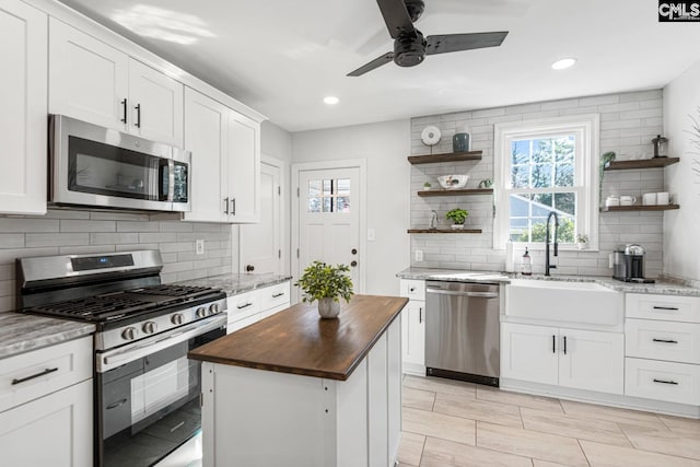 kitchen featuring a kitchen island, white cabinetry, and stainless steel appliances