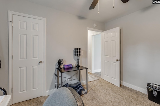 home office with a ceiling fan, light carpet, and baseboards