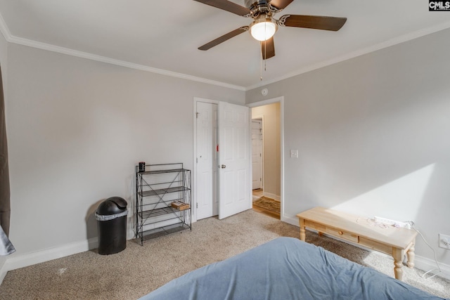 bedroom featuring light colored carpet, crown molding, baseboards, and ceiling fan