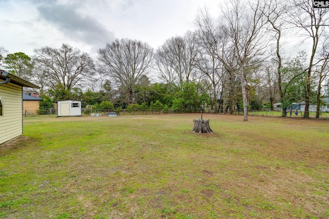 view of yard with an outdoor structure, a storage shed, and fence