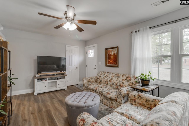 living area with a healthy amount of sunlight, visible vents, baseboards, and wood finished floors