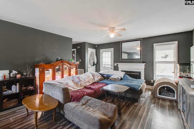 bedroom with dark wood-type flooring, a fireplace, and a ceiling fan