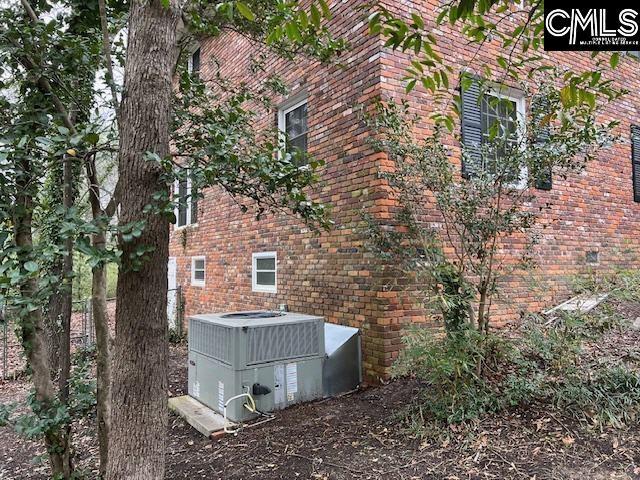 view of side of property with central AC unit and brick siding