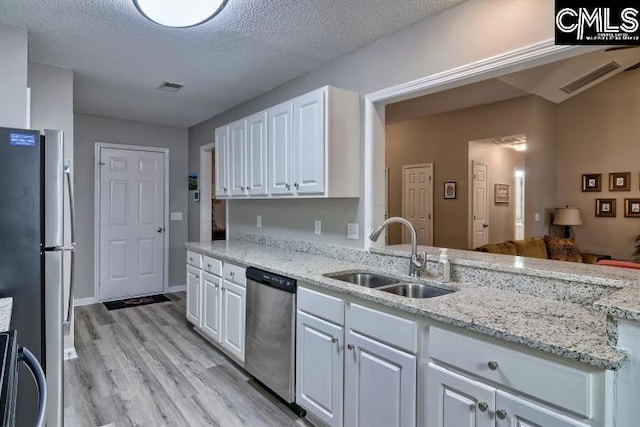 kitchen with visible vents, stainless steel appliances, a sink, and white cabinetry