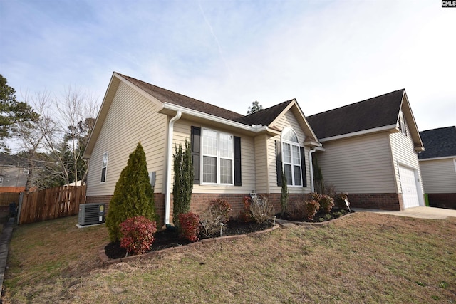 view of property exterior featuring central air condition unit, a garage, fence, a yard, and concrete driveway