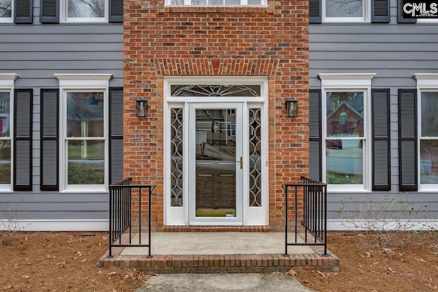 view of exterior entry featuring brick siding