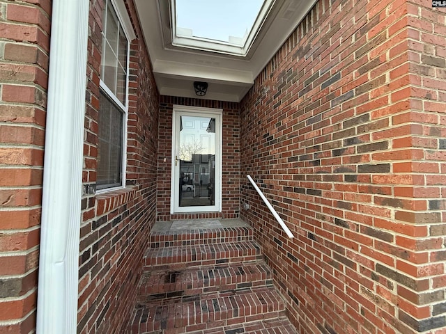 view of exterior entry featuring brick siding