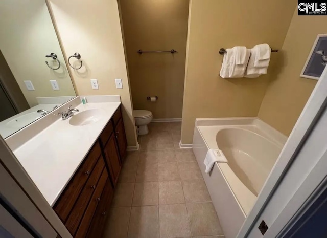 full bath with a garden tub, toilet, vanity, baseboards, and tile patterned floors