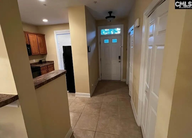 interior space featuring recessed lighting, light tile patterned flooring, and baseboards