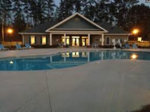 outdoor pool with a patio and an outdoor structure