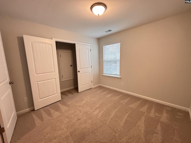 unfurnished bedroom featuring baseboards, a closet, visible vents, and carpet flooring