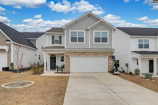 view of front facade featuring driveway, stone siding, an attached garage, a front lawn, and board and batten siding