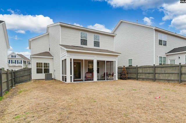 back of property with a sunroom, a fenced backyard, central AC unit, and a lawn