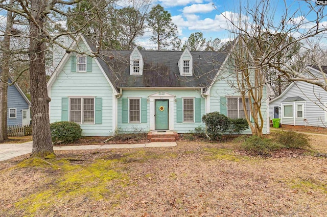 cape cod house with a front lawn