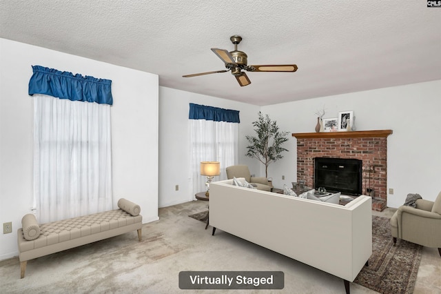 living area featuring a textured ceiling, a fireplace, a ceiling fan, and light colored carpet